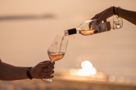 Woman serving-man a Rose Wine near a beach in Lake Leelanau, MI