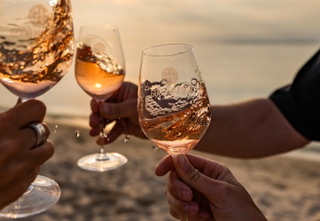 People swirling a glass of wine near a beach in Lake Leelanau, MI